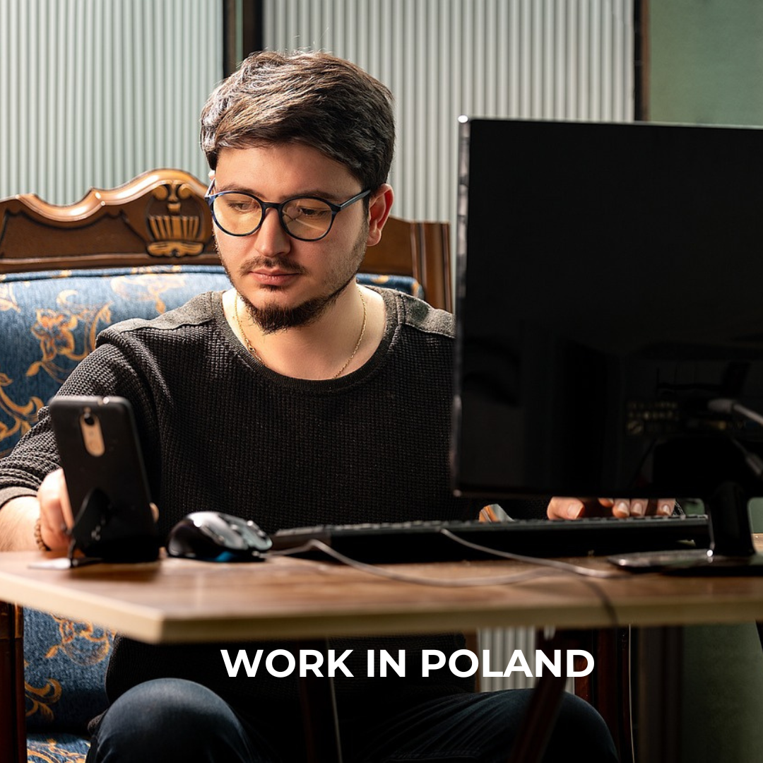 An Asian man working at the desk. "Work in Poland" caption in the lower part