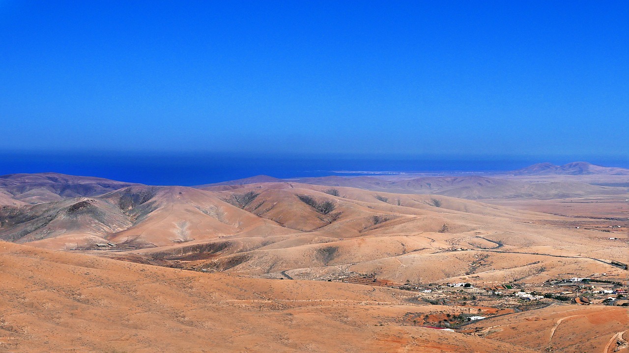 A sand desert with a hills and a blue sky 