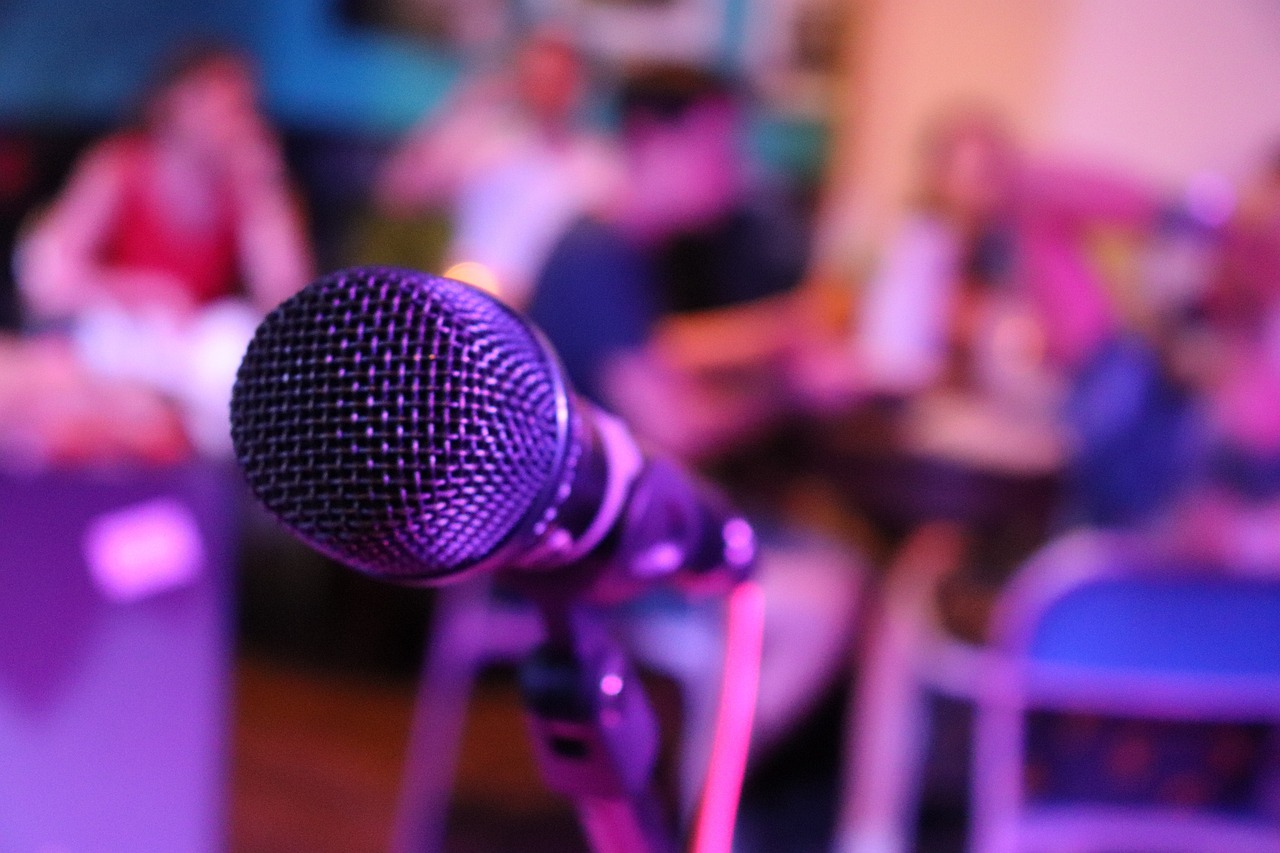A microphone and a blurred room with 4 people in the background